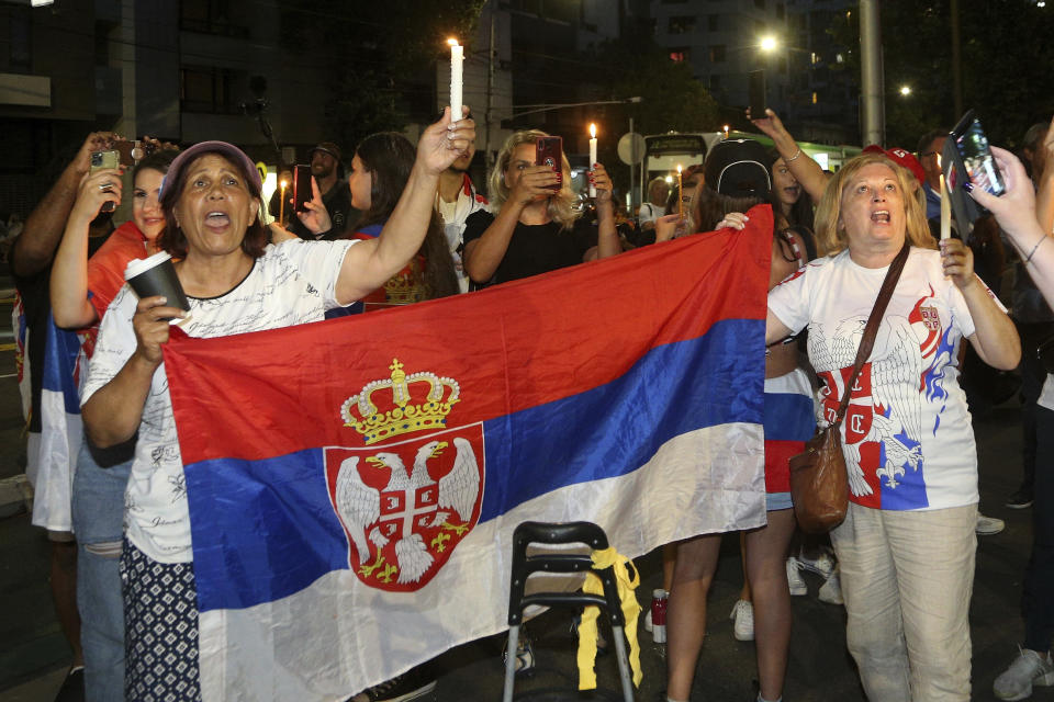 Supporters of Serbia's Novak Djokovic protest and sing with candles outside a quarantine facility where Djokovic is believed to be staying, in Melbourne, Australia, Jan. 6, 2022. The Australian government has denied No. 1-ranked Djokovic entry to defend his title in the year's first tennis major and canceled his visa because he failed to meet the requirements for an exemption to the country's COVID-19 vaccination rules. (AP Photo/Hamish Blair)