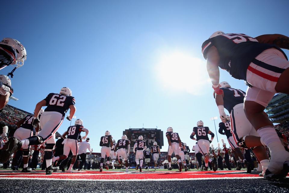 The Arizona Wildcats run onto the field before the NCAAF game against the Arizona State Sun Devils at Arizona Stadium on Nov. 25, 2022, in Tucson, Arizona. This year's game is the 96th annual Territorial Cup match between Arizona's rival schools.