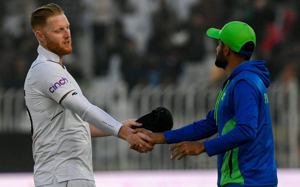 England's Ben Stokes (L) shakes hands with Pakistan's captain Babar Azam after their victory at the end of the fifth and final day of the first cricket Test match between Pakistan and England at the Rawalpindi Cricket Stadium, in Rawalpindi - AFP