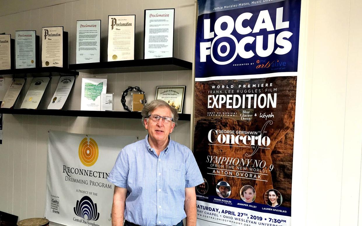 Warren Hyer, Central Ohio Symphony's executive director, stands next to a poster announcing the symphony's 43rd season in 2021. Hyer is retiring in July.