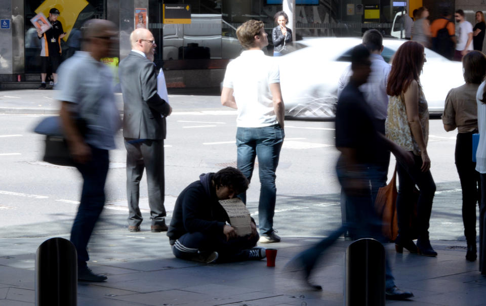 A homeless man waits for charity in the central business district of Sydney on April 2016.   The Australian economy has slowed as the country exits an unprecedented mining investment boom that has helped it avoid a recession for 24 years, with the jobless rate hovering around a decade high and wage growth and business investment outside the resources sector both tepid. / AFP / SAEED KHAN        (Photo credit should read SAEED KHAN/AFP via Getty Images)