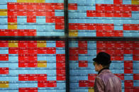 A man looks at an electronic stock board showing Japan's Nikkei 225 index at a securities firm in Tokyo Tuesday, Jan. 14, 2020. Asian shares followed Wall Street higher on Tuesday amid optimism that a trade deal between the U.S. and China will be a boon for the regional economy. (AP Photo/Eugene Hoshiko)