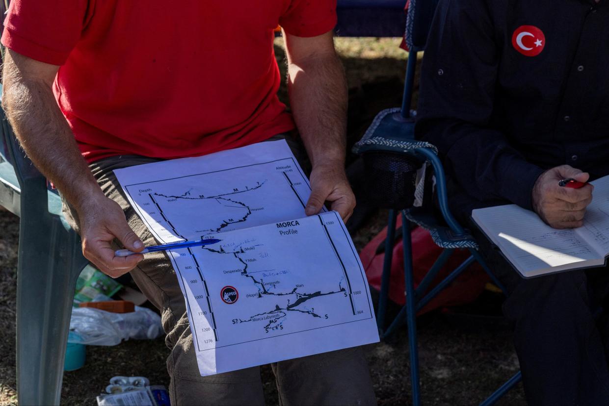 A rescuer holds a map of the Morca Cave during a meeting (Umit Bektas/Reuters)