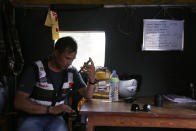 Arun Saiju, del grupo de voluntarios RYC-16, hablando por teléfono en la carpa donde se instalaron en un hospital de Bhaktapur, Nepal, para ayudar con las víctimas del coronavirus. Foto del 26 de mayo del 2020. (AP Photo/Niranjan Shrestha)