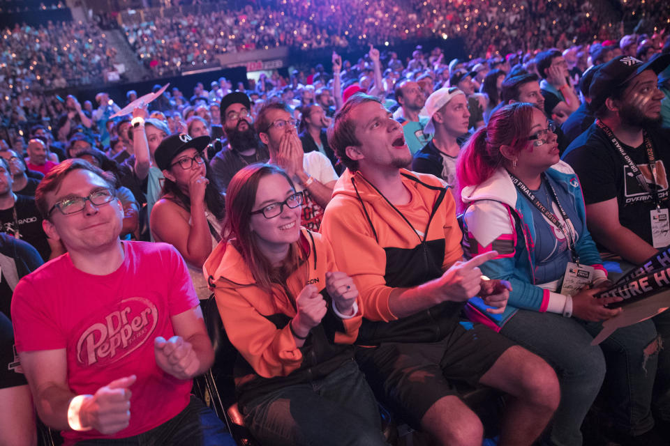 FILE - In this July 28, 2018 file photo, Philadelphia Fusion fans react as the London Spitfire takes the lead during the Overwatch League Grand Finals competition at Barclays Center in the Brooklyn borough of New York. Most professional esports are devoid of female players at their highest levels, even though 45 percent of U.S. gamers are women or girls. Executives for titles like League of Legends and Overwatch say they are eager to add women to pro rosters, but many female gamers say they’re discouraged from chasing such careers by toxic behavior and other barriers. (AP Photo/Mary Altaffer, File)