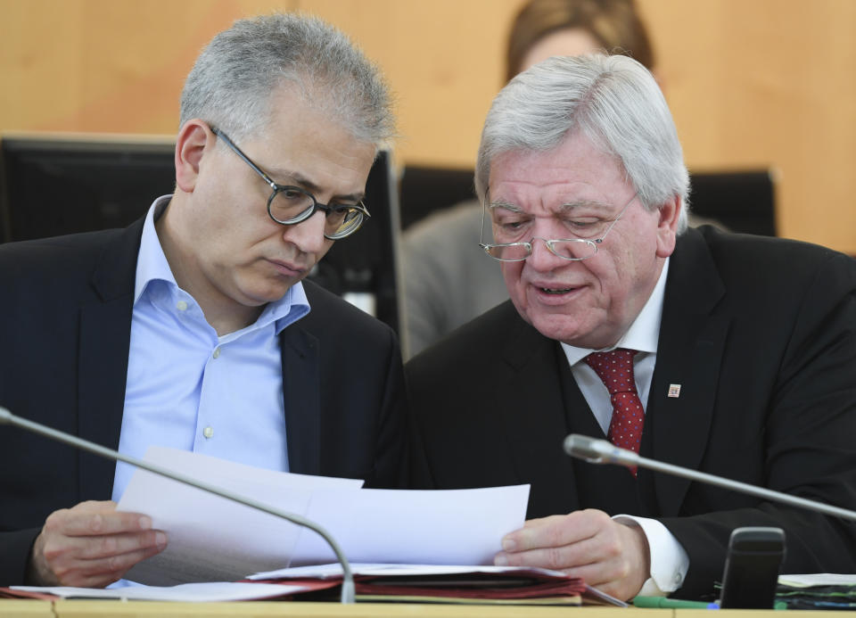 The March 21, 2018 photo shows Hesse governor Volker Pouffier, right, of the Christian Democratic Party CDU and Hesse Economy Minister Tarek Al-Wazir of the Green party talking in the Landtag state parliament of Hesse in Wiesbaden, western Germany. The stakes are unusually high for German Chancellor Angela Merkel’s government as the central region of Hesse votes in a state election this weekend. (Arne Dedert/dpa via AP)