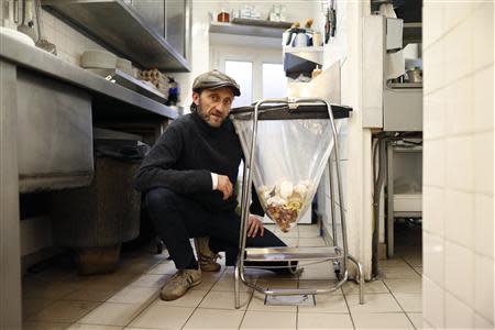 Stephan Martinez, owner of Le Petit Choiseuil bistrot, poses next to food waste garbage in the kitchen of his restaurant in Paris February 12, 2014. REUTERS/Charles Platiau