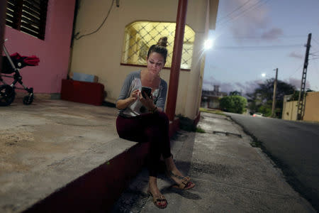 Dayali Lopez connects her mobile device to the internet in Varadero, Cuba, December 6, 2018. Picture taken December 6, 2018. REUTERS/Fernando Medina