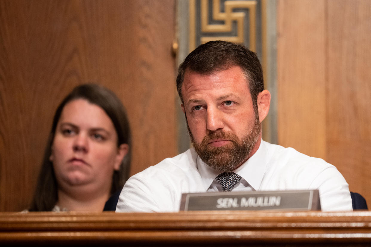 Senator Markwayne Mullin listens at his seat during a hearing.