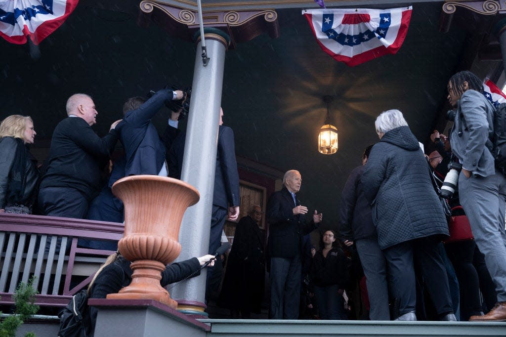 President Joe Biden, center speaks with supporters at a campaign event outside a private home in the Cathedral District neighborhood of Saginaw, Mich., on March 14, 2024.