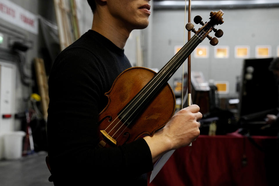 Violinist of the National Symphony Orchestra (NSO) Derek Powell hold one of a rare Italian string instruments from the 17th and 18th century used as he waits at the backstage prior to the start of the concert at Milan's La Scala theatre, Italy, Monday, Feb. 26, 2024. (AP Photo/Antonio Calanni)