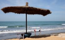 FILE PHOTO: Women stroll along the beach at Senegambia, Banjul, Gambia