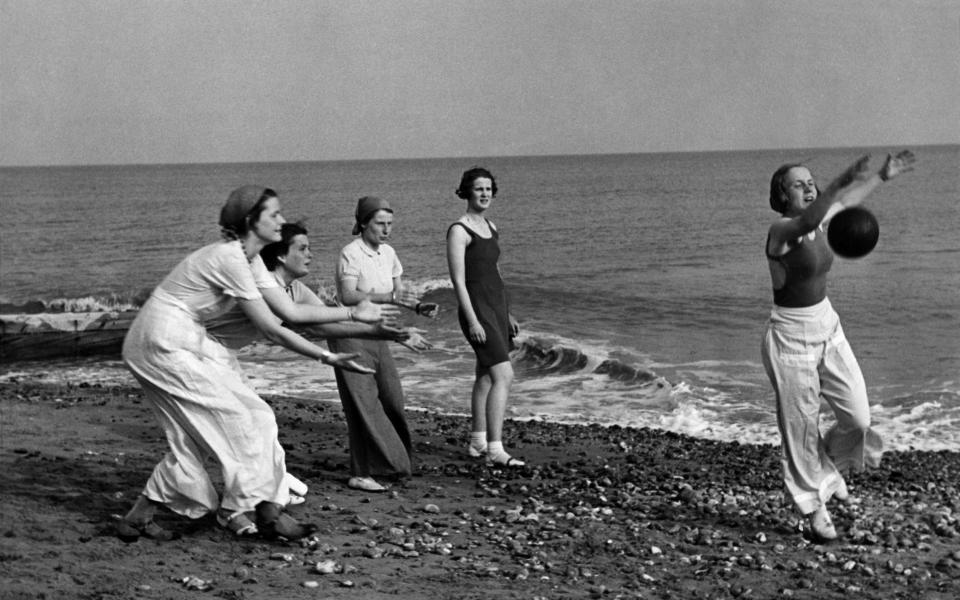 Black and white photo of young women playing volleyball on the beach - ullstein bild/ullstein bild