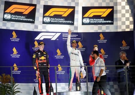 Motor Racing - Formula One - F1 Singapore Grand Prix 2018 - Singapore - September 16, 2018 Mercedes' Lewis Hamilton celebrates on theÊpodiumÊafter winning the race alongside second placed Red Bull's Max Verstappen and third placed Ferrari's Sebastian Vettel REUTERS/Kim Hong-Ji