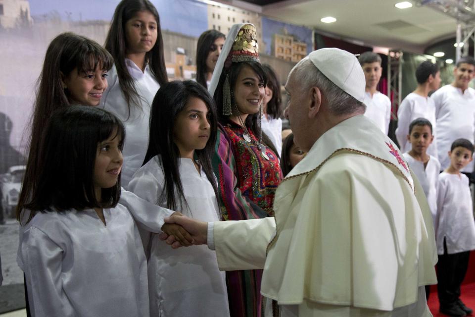 Pope Francis greets children at a meeting in the Phoenix Center of the Dheisheh refugee camp, near the West Bank town of Bethlehem