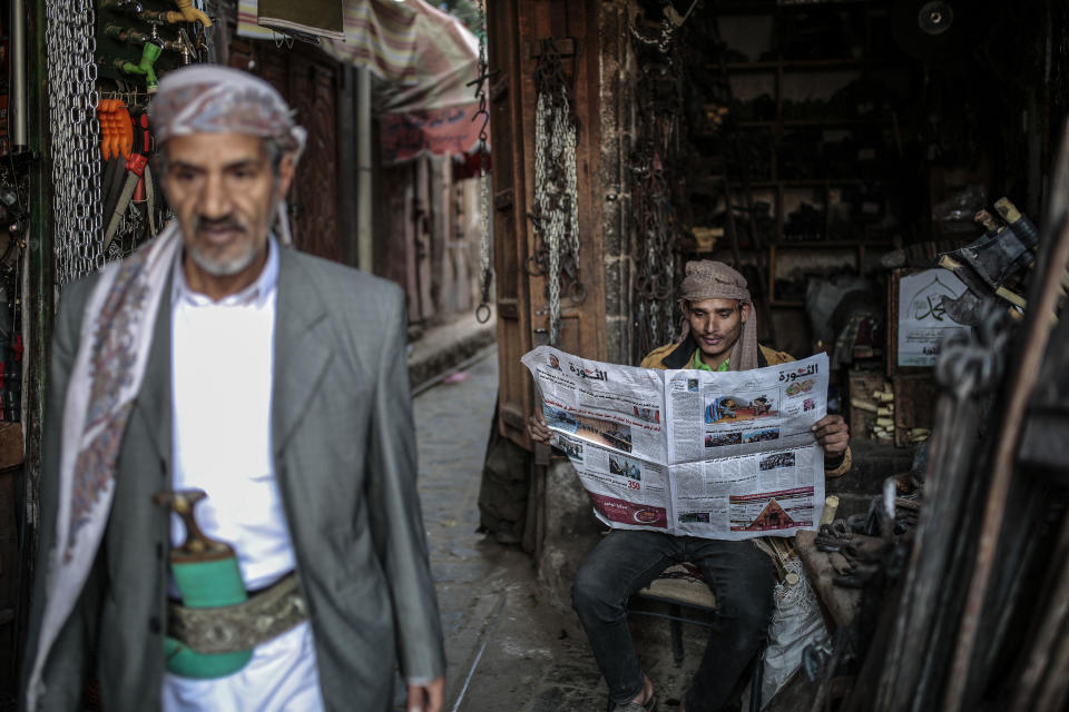 A man reads al-Thawra newspaper at Souq al-Melh marketplace in the old city of Sanaa, Yemen, Tuesday, Dec. 11, 2018. Yemen's warring sides agreed Thursday to an immediate cease-fire in the strategic port city of Hodeida, where fighting has disrupted vital aid deliveries and left the country on the brink of starvation in the 4-year-old civil war. (AP Photo/Hani Mohammed)