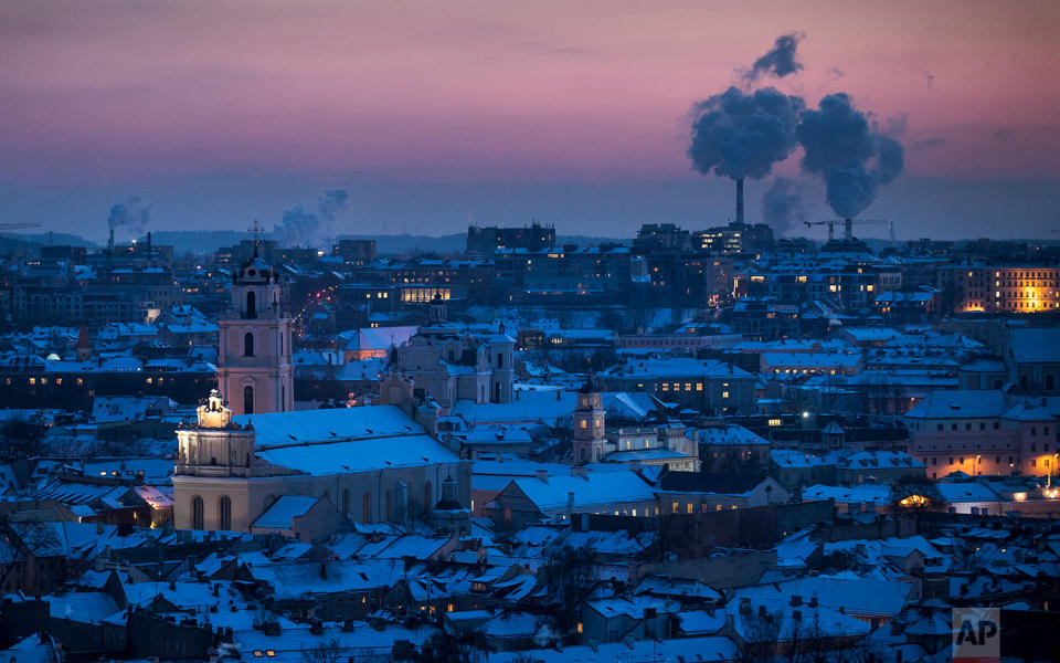 <p>Smoke rises from chimneys during a freezing winter evening over snow covered Vilnius, Lithuania. The air temperature was -15 degrees Celsius (5 degrees Fahrenheit). (AP Photo/Mindaugas Kulbis) </p>