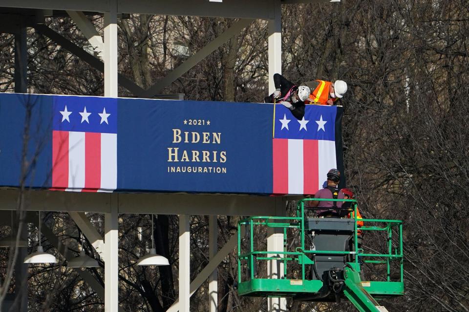 Workers adjust the bunting on a riser across from the White House on Thursday.  (Photo: MANDEL NGAN/AFP via Getty Images)