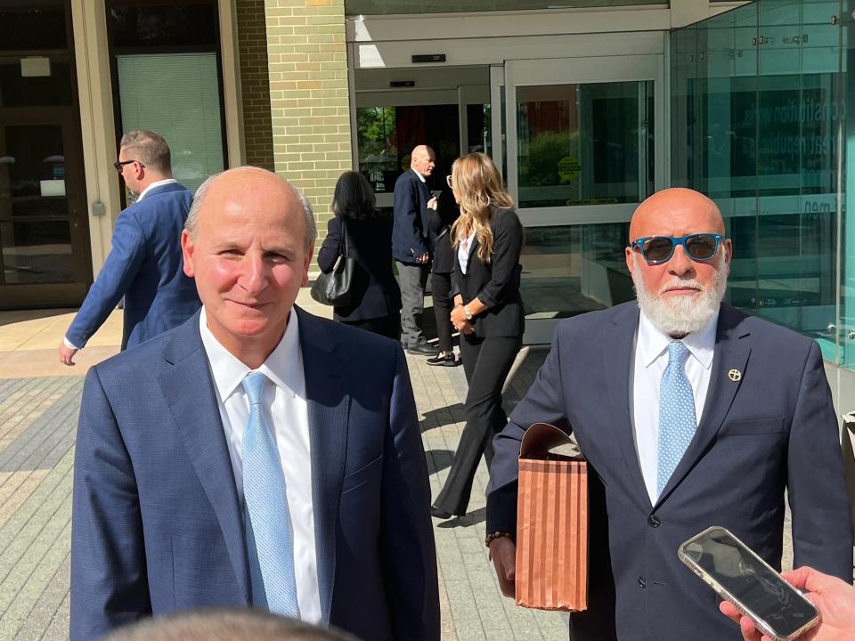 John Dalaly, right, listens as his attorney Raymond Cassar, left, speaks with reporters on Thursday, Sept. 14, 2023, outside the federal courthouse in Grand Rapids, Mich. Dalaly, 71, received a prison sentence of 28 months after pleading to guilty providing bribes to the former chair of the now defunct Michigan Medical Marihuana Licensing Board.