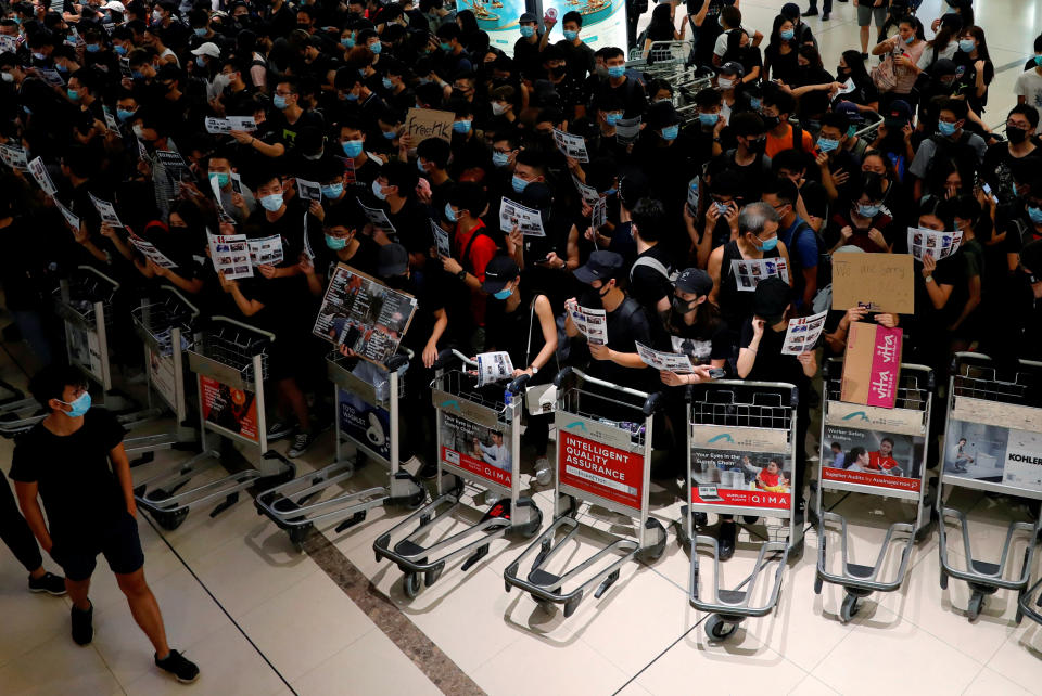 Anti-extradition bill protesters use trolleys to stop passengers from entering the security gates during a mass demonstration after a woman was shot in the eye, at the Hong Kong international airport, in Hong Kong China August 13, 2019. (Photo: Tyrone Siu/Reuters)