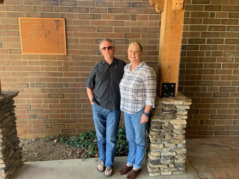 Mike and Anna Tuziw stand in front of the Madison High School entrance. The couple's organization, FATE Foundation, issued $46,000 to Madison County students in 2022.
