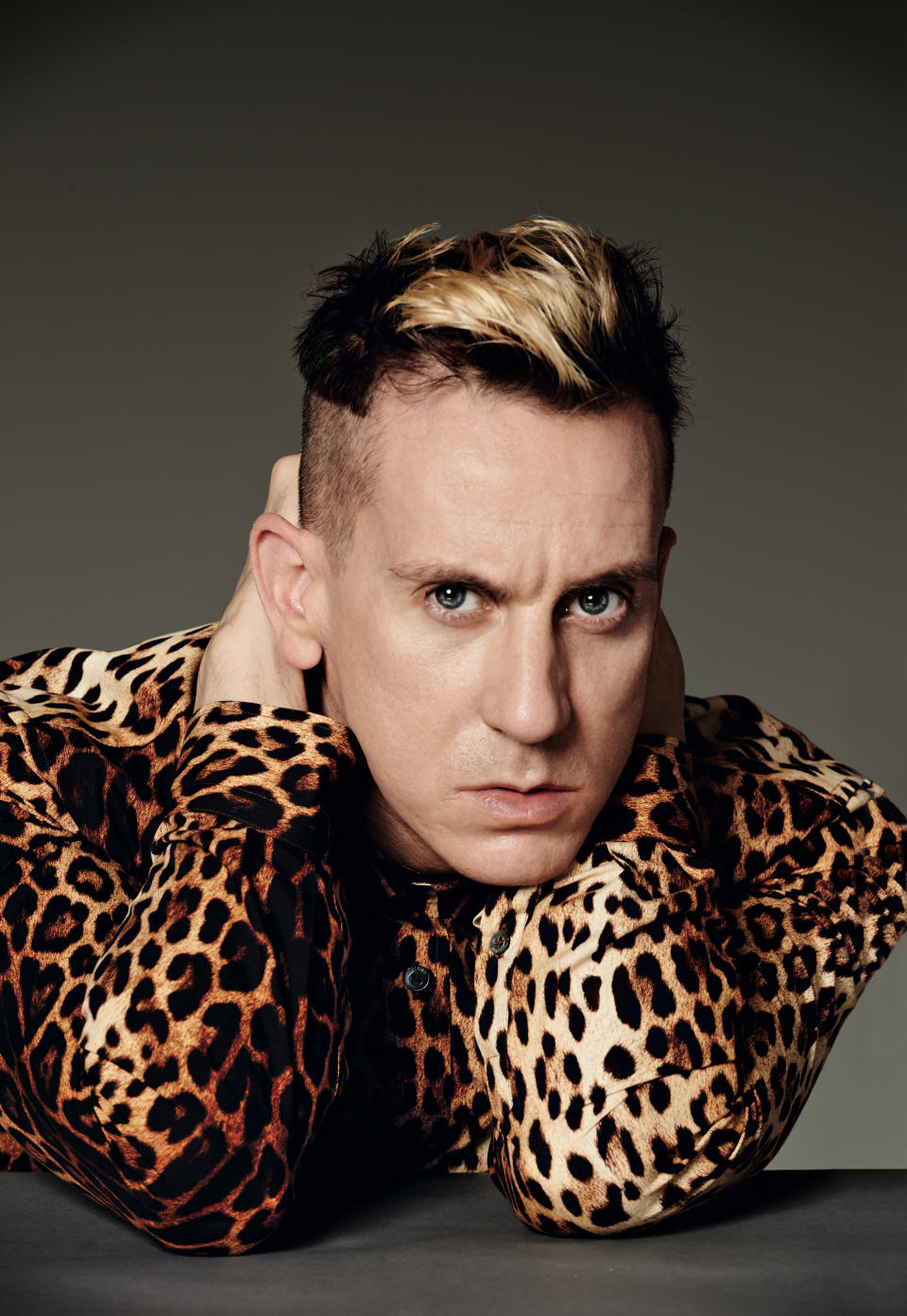 A headshot of creative director of Moschino Jeremy Scott, wearing a leopard print long-sleeve shirt