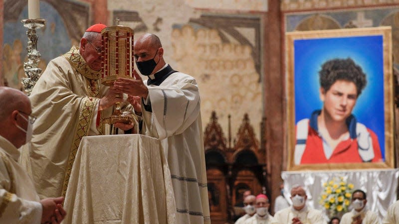 Cardinal Agostino Vallini, left, holds a relic of 15-year-old Carlo Acutis, an Italian boy who died in 2006 of leukemia, during his beatification ceremony celebrated in the St. Francis Basilica, in Assisi, Italy on Oct. 10, 2020. - Photo: Gregorio Borgia (AP)