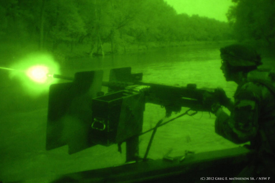 US Naval Special Warfare Combatant-crew Crewman fires a 50 caliber machine gun from Riverine boat in the darkness of night, as seen through night vision goggles.  Photo: (C) 2011 Greg E. Mathieson Sr. / NSW Publications, LLC