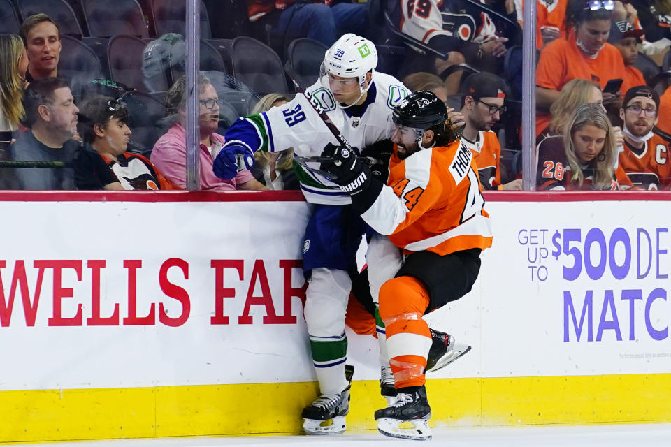 Philadelphia Flyers' Nate Thompson, right, and Vancouver Canucks' Alex Chiasson collide during the second period of an NHL hockey game, Friday, Oct. 15, 2021, in Philadelphia. (AP Photo/Matt Slocum)