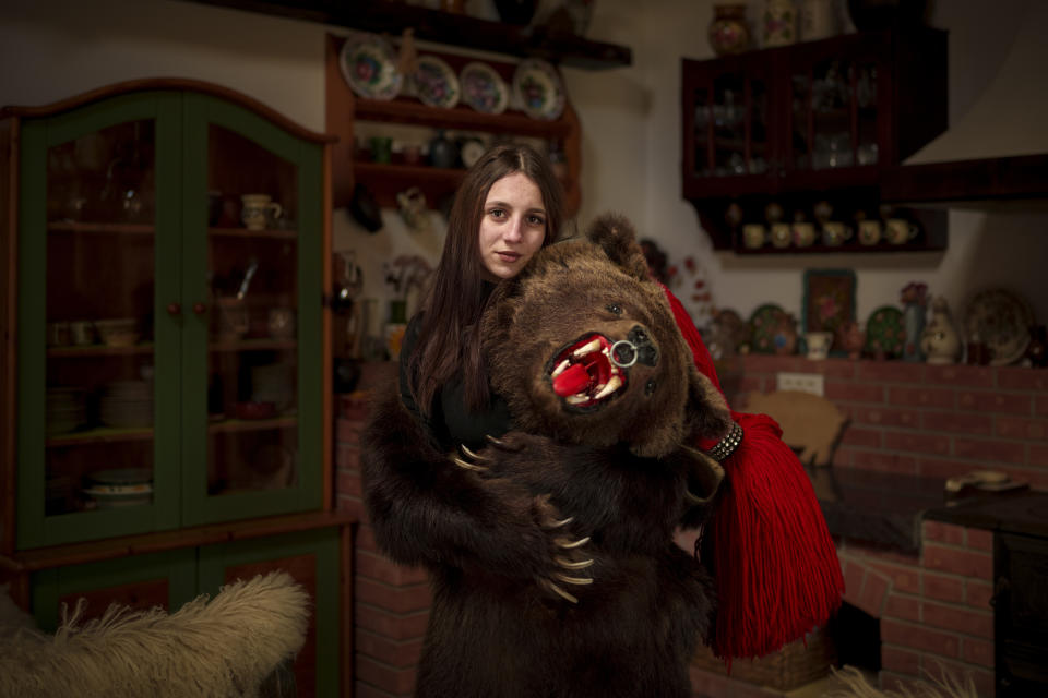 Catalina, 18 years-old, a member of the Sipoteni bear pack, poses for a portrait in Comanesti, northern Romania, Wednesday, Dec. 27, 2023. Catalina first wore the bear fur costume when she was 15 years-old, feels joy when wearing the costume and is proud to be a part of the centuries tradition. (AP Photo/Andreea Alexandru)