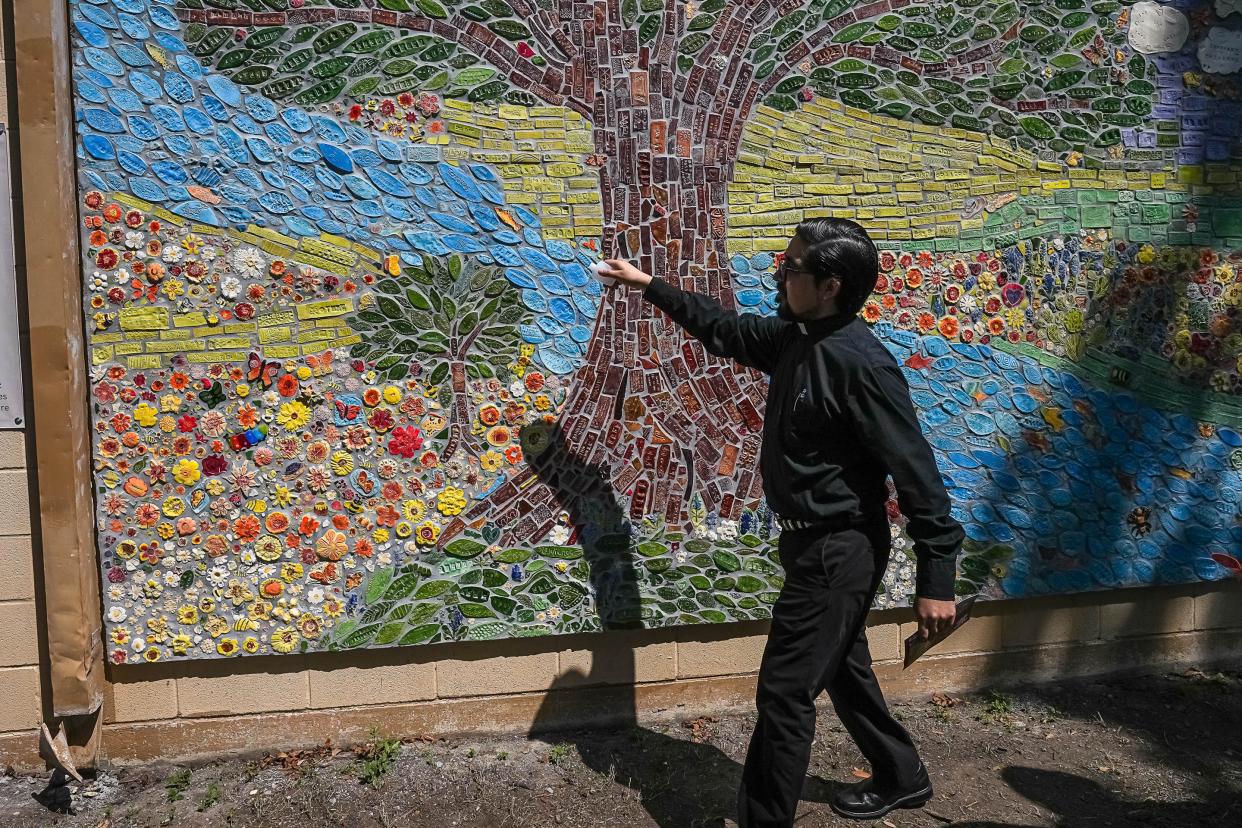 Father Matthew De Leon blesses the mural at Jardin de Los Heroes Park in Uvalde in August. Artist Wanda Montemayor and the Uvalde Love Project created the piece using tiles created by over 2,000 individuals with a total of around 5,000 pieces.