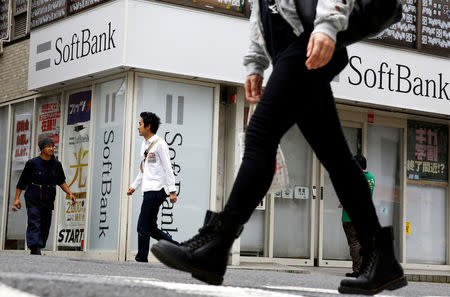 People walk past a retail shop of the SoftBank telecommunications company in Tokyo, Japan, May 10, 2016. REUTERS/Thomas Peter/File Photo