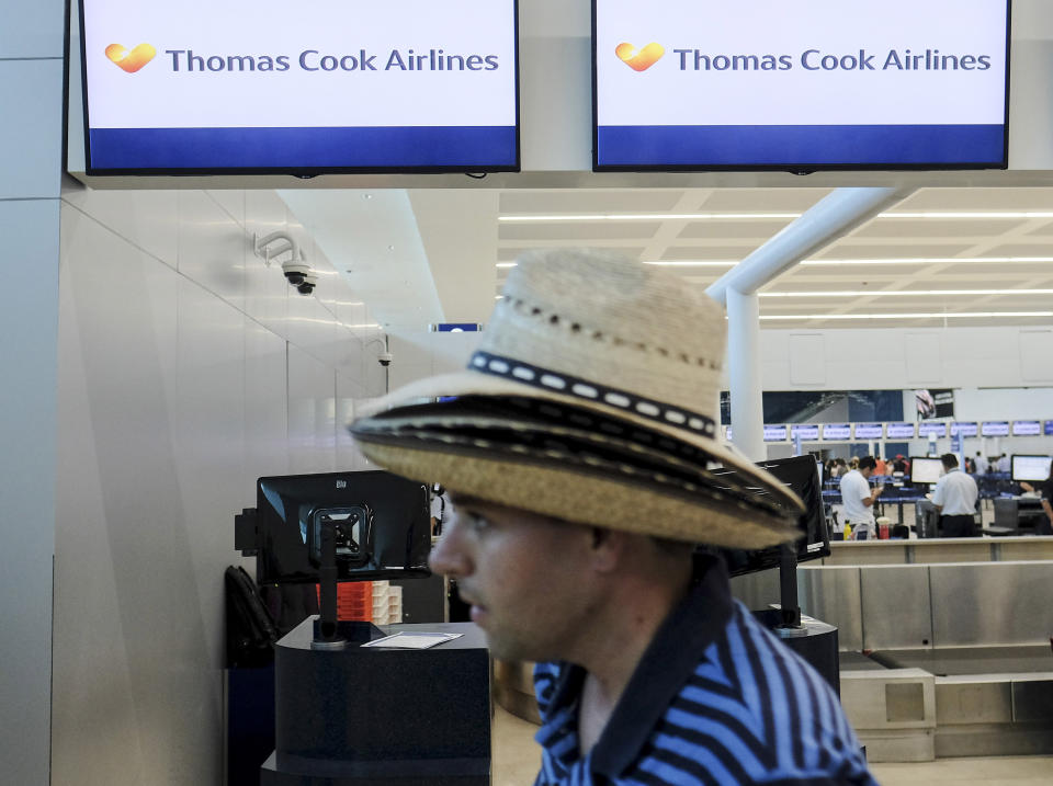 A tourist walks past a Thomas Cook counter at the Cancun airport in Mexico, Monday, Sept. 23, 2019. British tour company Thomas Cook collapsed early Monday after failing to secure emergency funding, leaving tens of thousands of vacationers stranded abroad. (AP Photo/Victor Ruiz)
