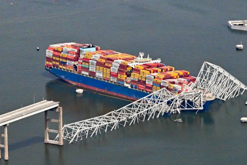 A damaged container ship rests next to a bridge pillar Tuesday in the Patapsco River after crashing into and destroying the Francis Scott Key Bridge at the entrance to Baltimore harbor in Maryland. Several workers were atop the bridge and making repairs to the asphalt roadway when the structure collapsed. Six construction workers, who had been filling potholes on the bridge, are presumed dead. Photo by David Tulis/UPI