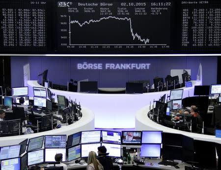 Traders are pictured at their desks in front of the DAX board at the stock exchange in Frankfurt, Germany, October 2, 2015. REUTERS/Staff/remote