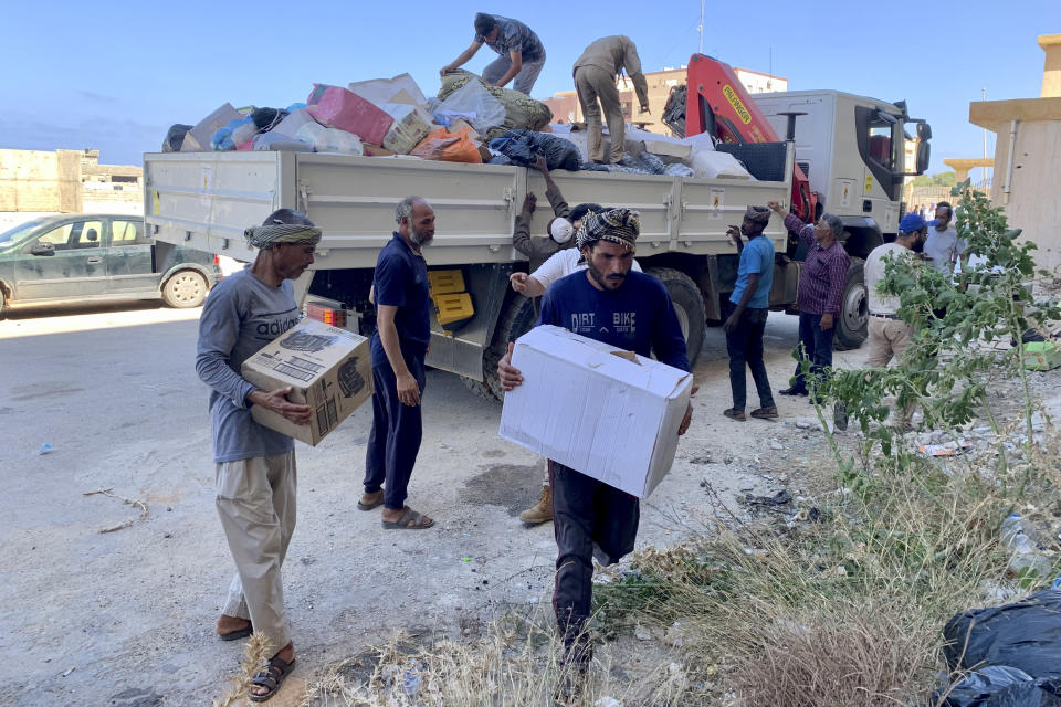 FILE - People deliver donated aid to a flash flood-destroyed city of Derna, Libya, Saturday, Sept. 16, 2023. For many Libyans, the disastrous flooding that killed more than 11,000 people have fostered a sense of unity. The collective grief has morphed into a rallying cry of national unity in a country blighted by 12 years of conflict and division. (AP Photo/Yousef Murad, File)