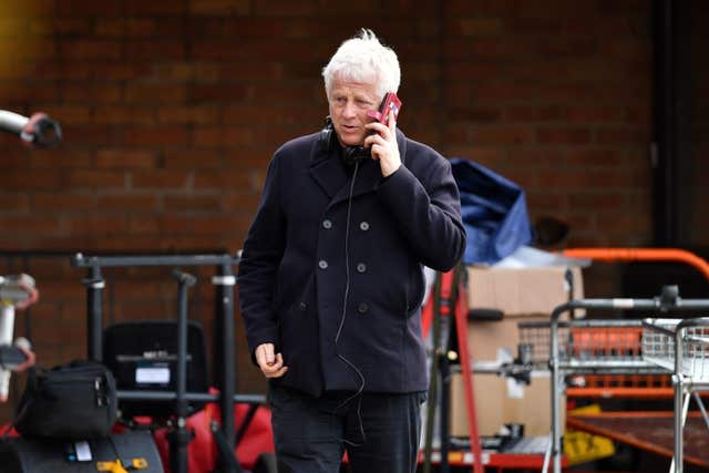 Richard Curtis talking on a mobile