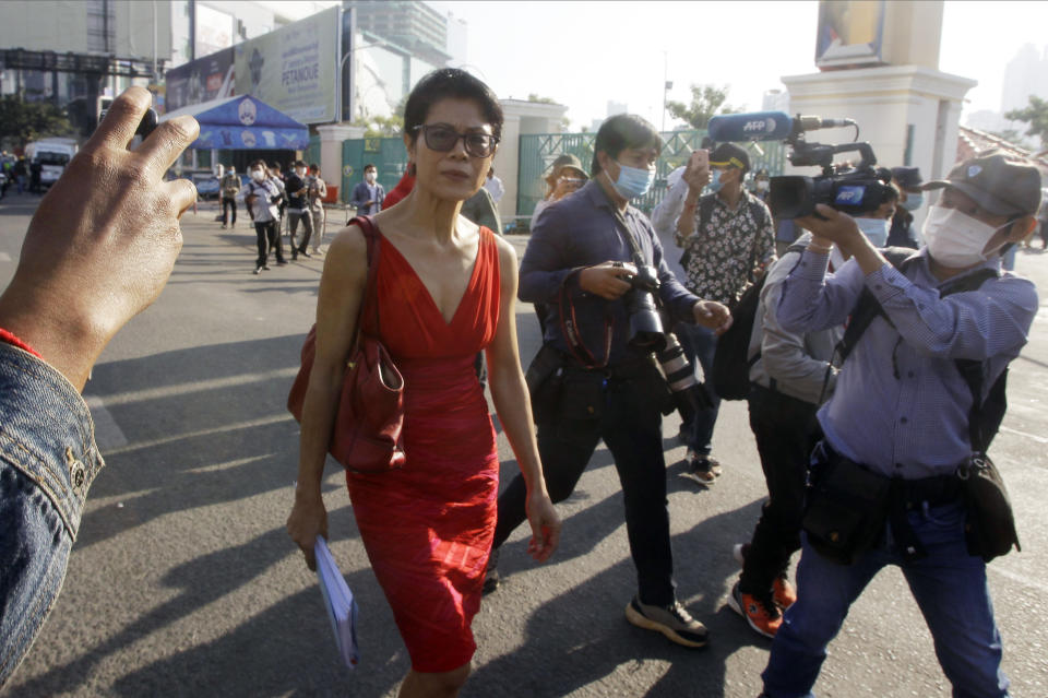 Theary Seng, center, a Cambodian-American lawyer, walks in front of Phnom Penh Municipal Court in Phnom Penh, Cambodia, Thursday, Jan. 14, 2021. Theary Seng said Thursday she was being persecuted for her political opinion as she and dozens of other government critics charged with treason and other offenses returned to court in a trial criticized by rights advocates. (AP Photo/Heng Sinith)