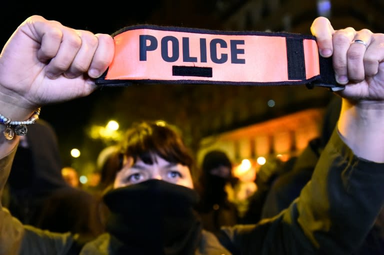 A French police officer holds her armband as she demonstrates in Paris on October 20, 2016