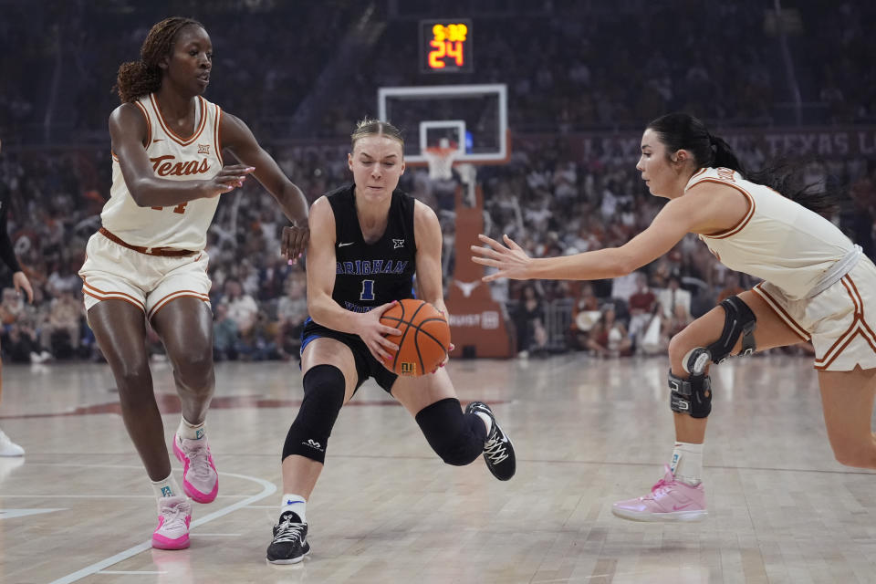 BYU guard Amari Whiting (1) drives between Texas forward Amina Muhammad, left, and guard Shaylee Gonzales during the first half of an NCAA college basketball game in Austin, Texas, Saturday, March 2, 2024. (AP Photo/Eric Gay)