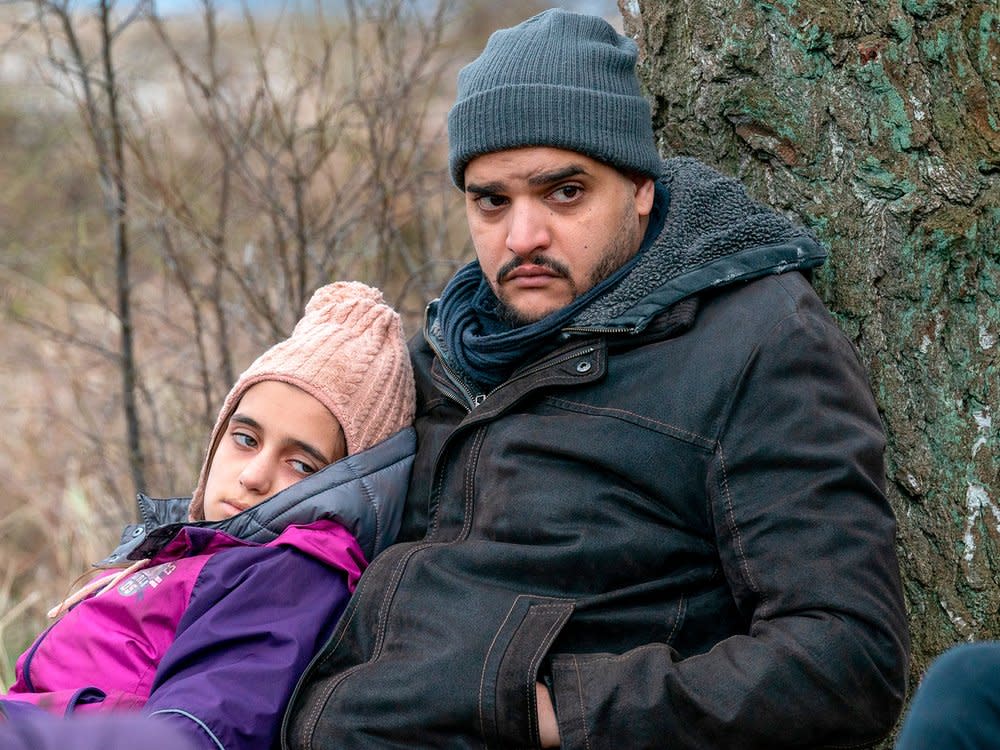 "Der Usedom-Krimi: Geburt der Drachenfrau": Ahmad Bashmani (Yasin El Harrouk) wartet mit seiner Tochter Amira (Valtina Simogy) und anderen Geflüchteten auf den Transporter. (Bild: NDR/ARD Degeto/Oliver Feist)