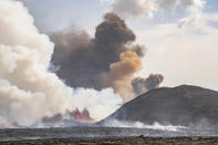 Ash rising behind Sýlingarfell, as magma hits groundwater triggering phreatomagmatic activity from a volcano in Grindavik, Iceland, Wednesday, May 29, 2024. A volcano in southwestern Iceland erupted Wednesday for the fifth time since December, spewing red lava that once again threatened the coastal town of Grindavik and led to the evacuation of the popular Blue Lagoon geothermal spa. (AP Photo/Marco di Marco)