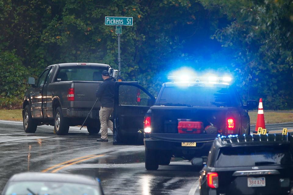 An officer walks past the pickup truck involved in an officer-involved shooting at the intersection of Precinct and Pickens streets in Lakeville Friday morning.