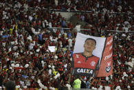 Fans hold up a banner that shows Arthur Vinicius, one of the 10 teenage players killed by a fire at the Flamengo training center last Friday, during a homage to the boys ahead of a soccer match between Flamengo and Fluminense, at the Maracana Stadium, in Rio de Janeiro, Brazil, Thursday, Feb. 14, 2019. (AP Photo/Leo Correa)