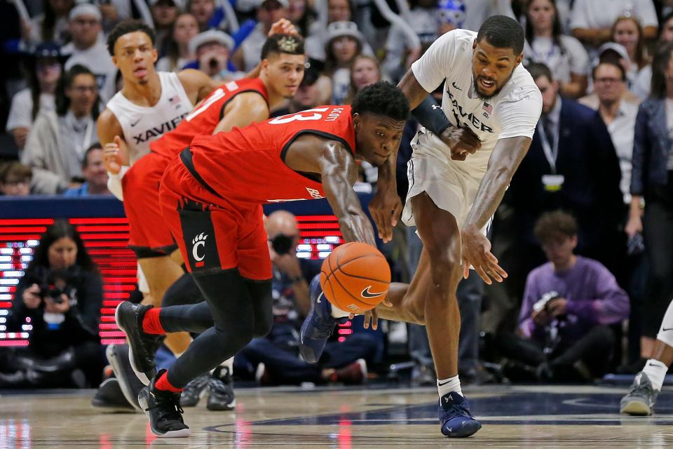 Xavier Musketeers forward Naji Marshall (13) and Cincinnati Bearcats forward Trevon Scott (13) chase a loose ball in the second half of the Skyline Chili Crosstown Shootout game at the Cintas Center Dec. 7, 2019. Scott now leads UC alumni in the TBT back at the Cintas Center this July.