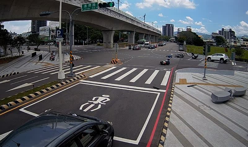 黑衣機車騎士原本成功閃躲撞擊，卻因為停在原地回頭看，最後遭受波及。(圖／翻攝畫面)