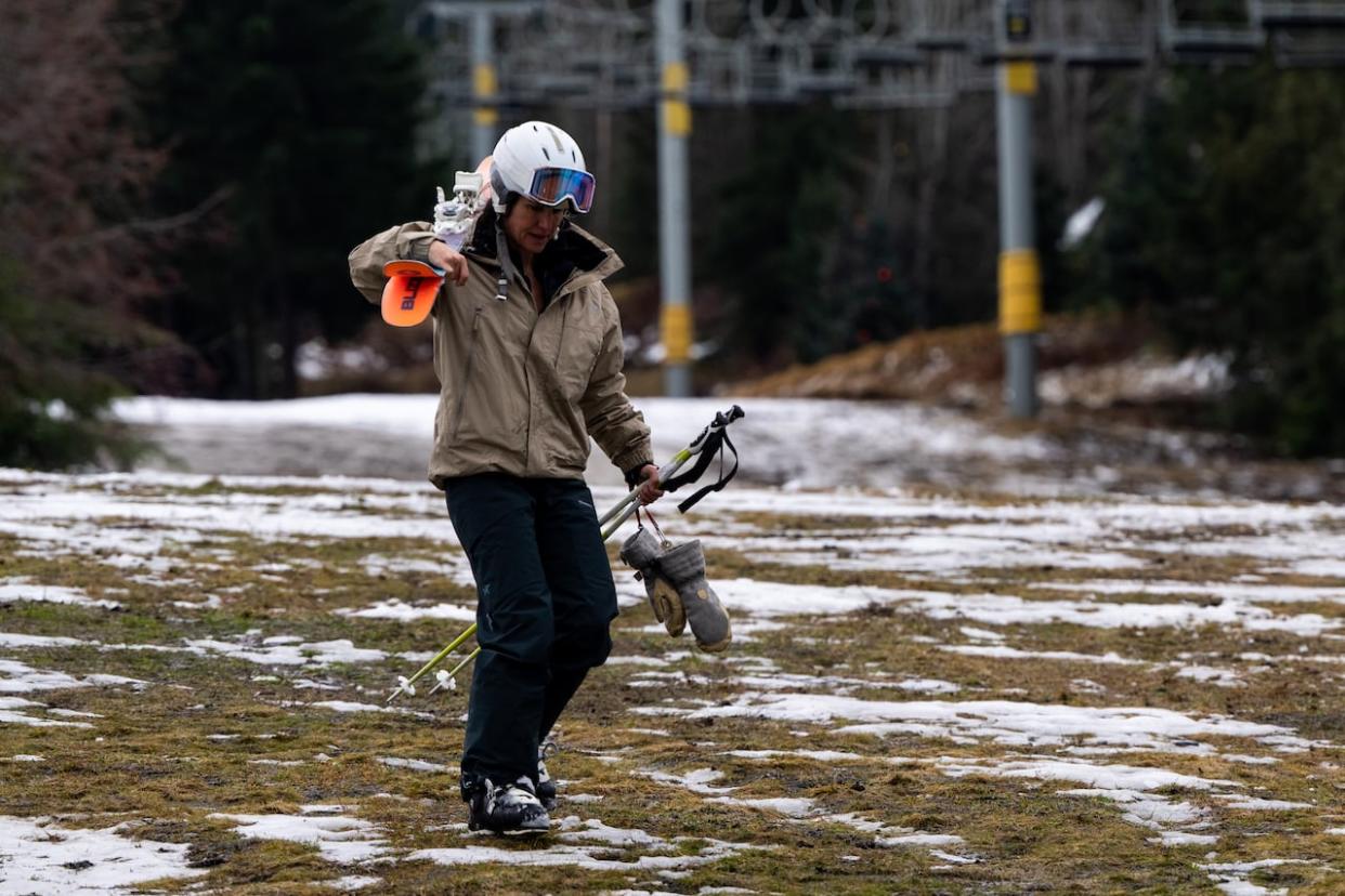 A skier walks down a patchy ski slope in Whistler, B.C., on Friday. (Ethan Cairns/The Canadian Press - image credit)