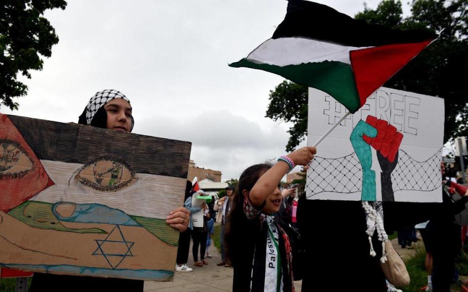 Rama Allen, 13, left, and her sister, Yasmin, 7, joined about 250 others Saturday evening at Mill Creek Park on the Country Club Plaza for a pro-Palestinian rally condemning the Israeli occupation of Palestine and the violation of human rights. Protestors called for an end to violence against Palestinians, the displacement of families from the East Jerusalem neighborhoods of Sheikh Jarrah and Silwan, the desecration of the Al-Aqsa mosque, and the recent military attacks on civilian populations in Gaza and throughout greater Palestine.