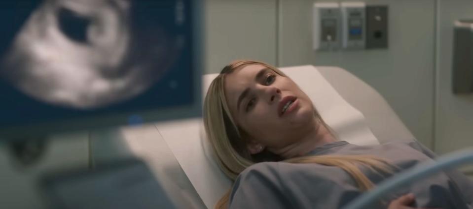 Emma Roberts as Anna, lying on a bed with a baby scan in shot