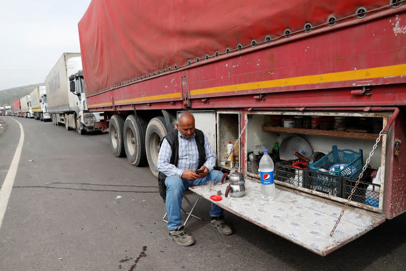 A driver sits next to his truck at the Cilvegozu border gate in Reyhanli